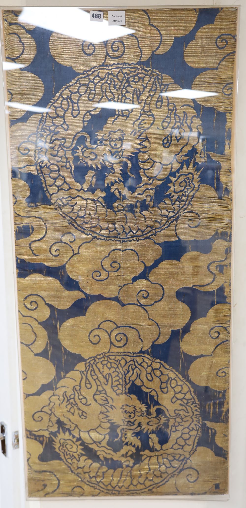 A Chinese gold thread embroidered panel, depicting celestial dragons amongst stylised clouds